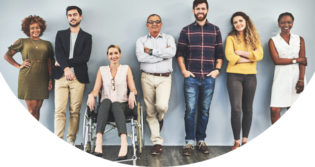 A woman stands next to and smiles at a disabled man in a wheelchair.