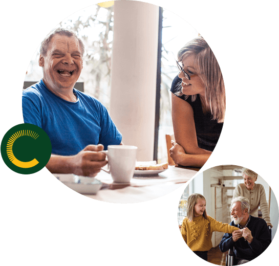 A man with a disability laughing and holding a cup of coffee while a woman stares at him smiling and a little girl holding the hand of an older man in a wheelchair with an older woman pushing from behind, all are smiling