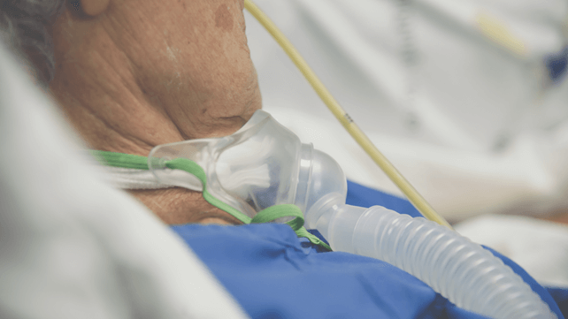 Elderly using tracheostomy ventilator for breathing
