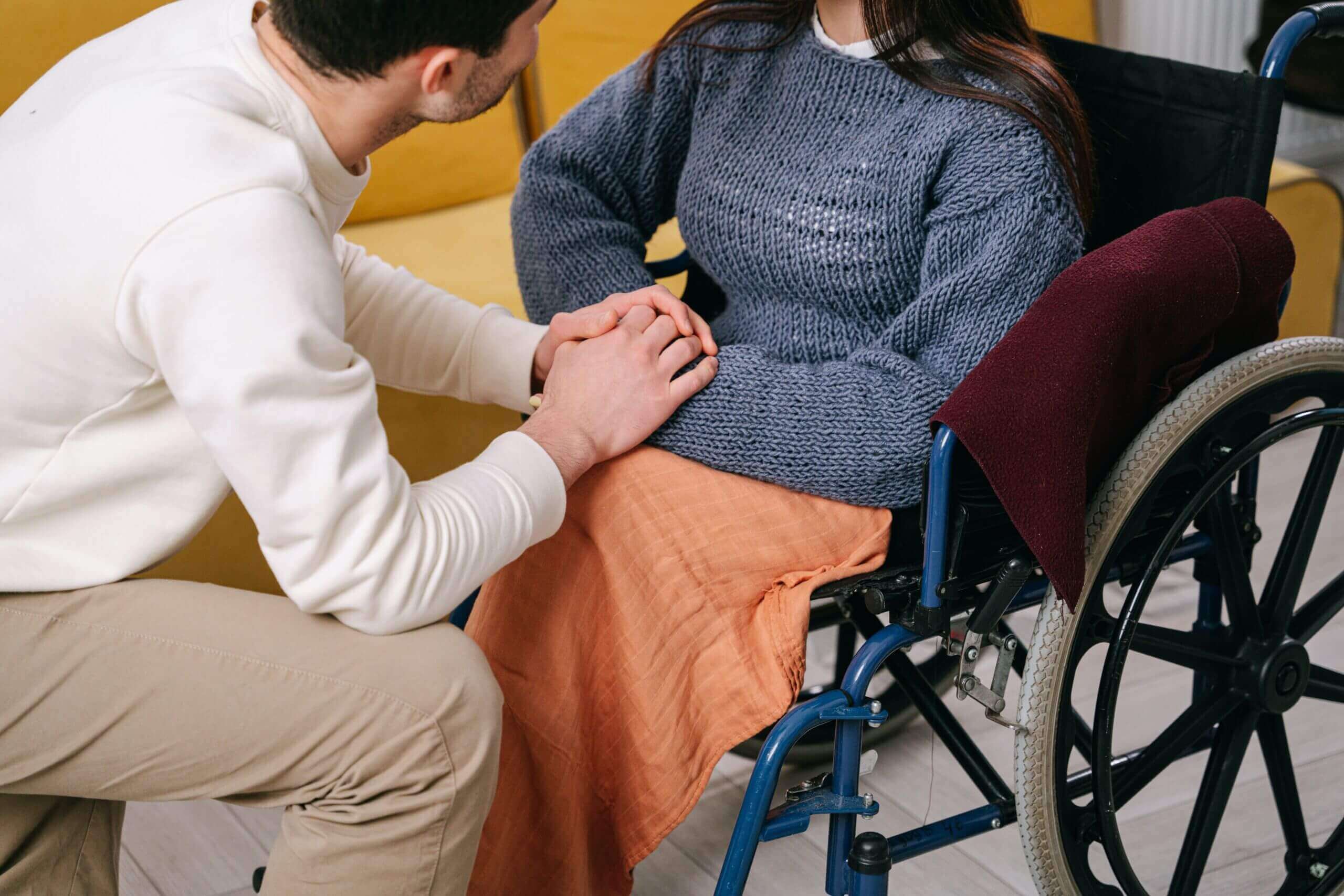 Boy in wheel chair smiling with adult carer