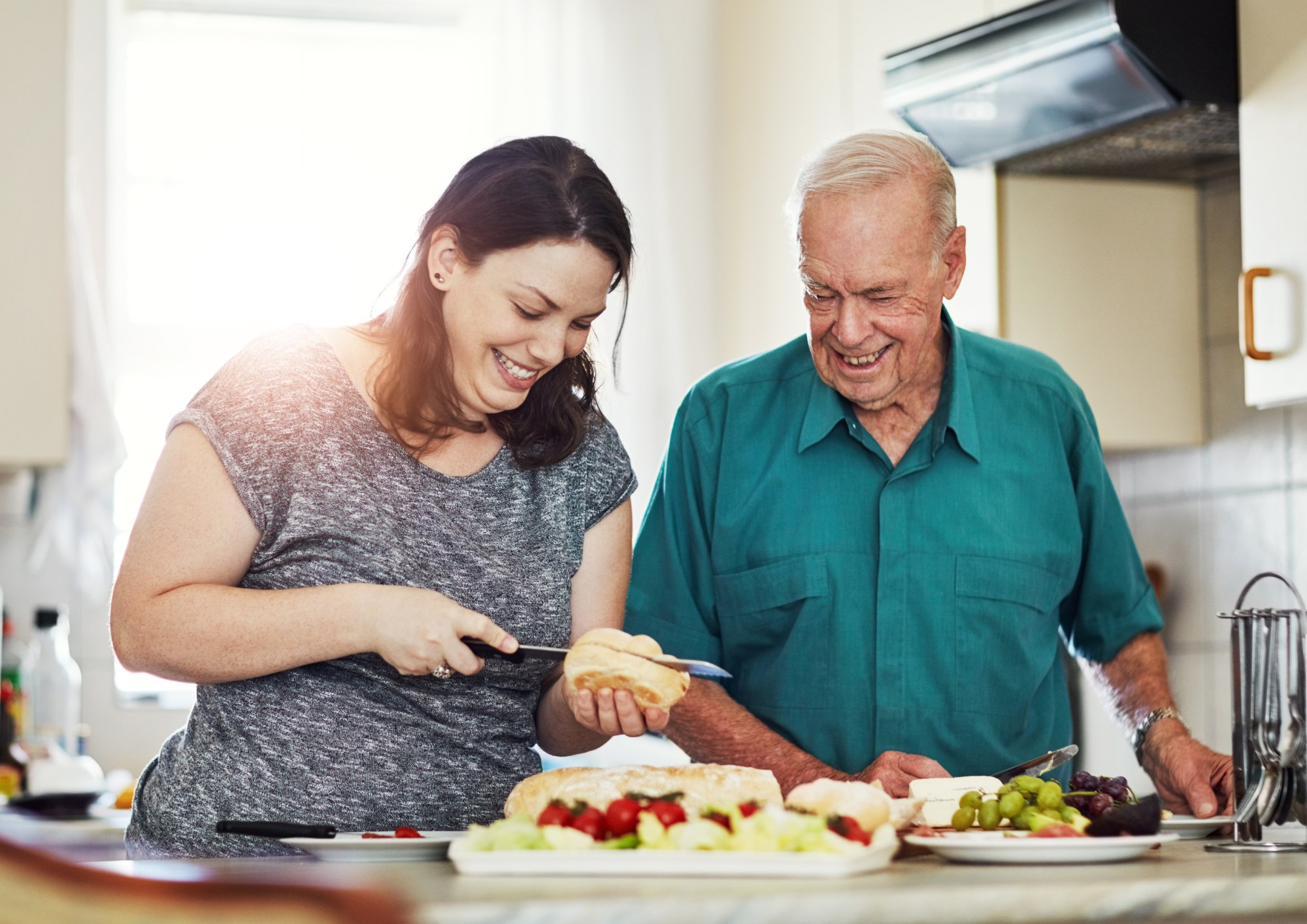 Blog Pictures (2) A young woman and an elderly man make sandwiches in the kitchen.